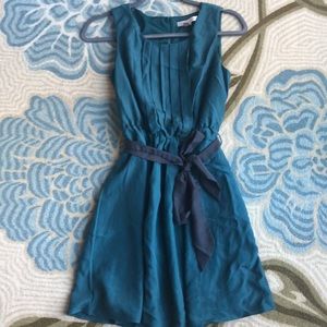 Dark green silk dress with black bow tie around waist